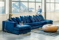 Paso Doble niebieska sofa narożna z małymi poduszkami w aranżacji