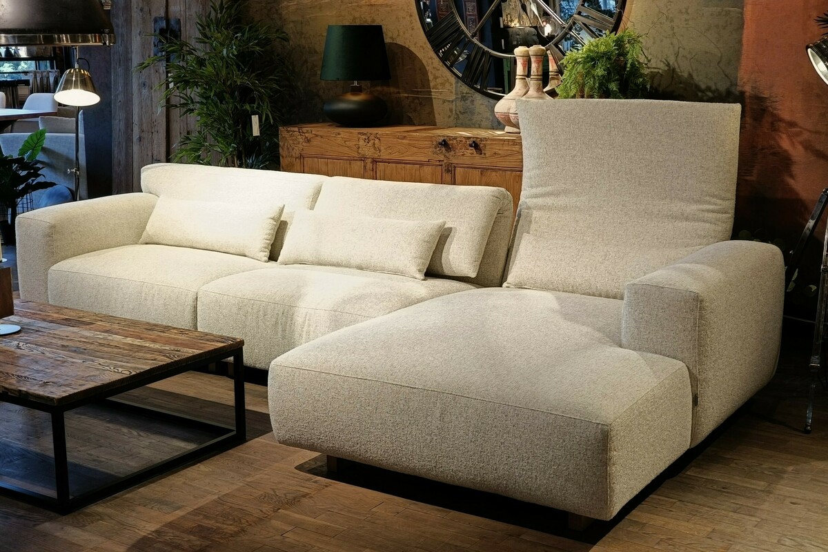 Vesta Fold Furninova. Sofy modułowe Katowice. Jasny narożnik do salonu. Sofa na tle wzorzystej tapety. Ciekawe wazony ceramiczne. Srebrna lampa podłogowa