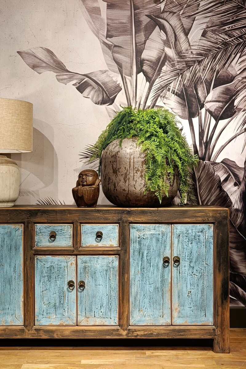 Kolorowa komoda na tle tapety w liście