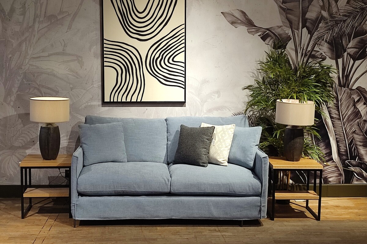 Wygodna mała sofa z funkcją spania, niebieska kanapa z luźnym pokrowcem, czarno-biały obraz moder line art