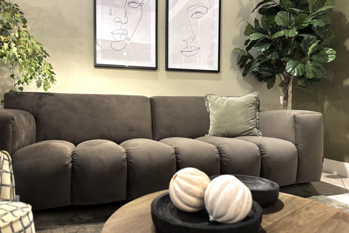 Czekoladowa sofa Vesta Quilt. Trzyosobowa  sofa welurowa. Sofa w kolorze mocha mousse. Oliwkowe ściany w salonie i zielony dywan. 