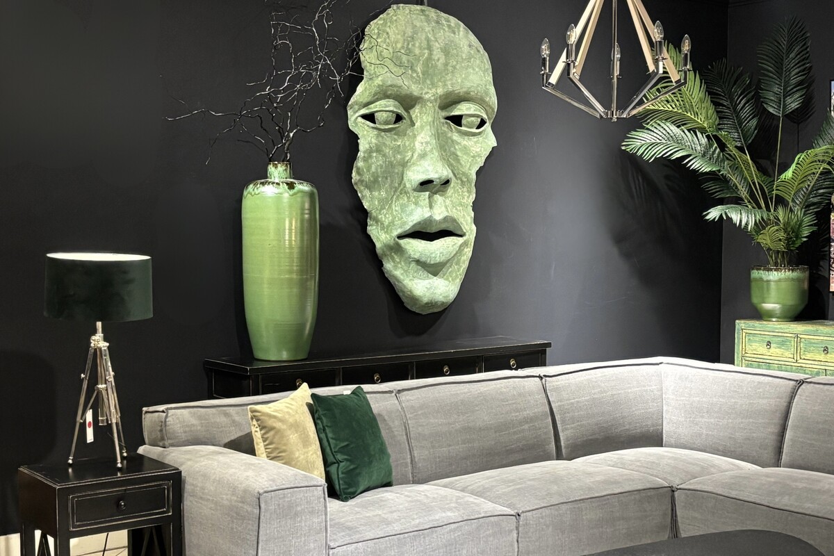 Rzeźba twarz, zielona maska twarz na czarnej ścianie. Płaskorzeźba w kolorze zielonym, czarna konsola z szufladami. Oryginalna duża płaskorzeźba ścienna. Konsola z szufladami.