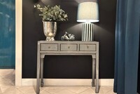 małą szara konsolka do korytarza, szarości we wnętrzu, turkusowe zasłony, ceramiczna lampa stołowa, sreebrne dodatki do salonu, aranżacja konsoli