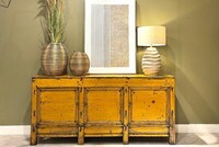 duża żółta komoda, duża komoda do salonu, oliwkowa ściana, ciekawe obrazy do gabinetu, beżowa lampa stołowa, kolorowe meble, oryginalne komody warszawa (1)