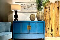 komoda w stylu Hampton, niebieska komoda na białej ścianie, styl hampton we wnętrzach, palmy we wnętrzach, obraz nadmorski, deski znad morze