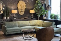 zielona kanapa, tynk dekoracyjny, maska, oryginalna rzeźba maska, twrz maska, brązowy fotel, fotel obrotowy, stolik geometryczny z kamiennym blatem, nowoczesny salon, dużzy zielony nar