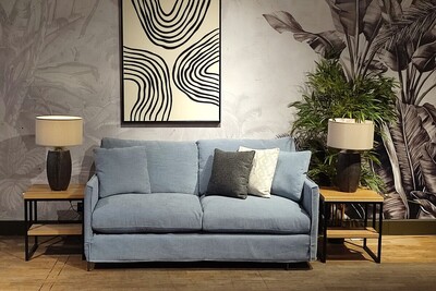 Wygodna mała sofa z funkcją spania, niebieska kanapa z luźnym pokrowcem, czarno-biały obraz moder line art