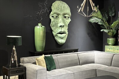 Rzeźba twarz, zielona maska twarz na czarnej ścianie. Płaskorzeźba w kolorze zielonym, czarna konsola z szufladami. Oryginalna duża płaskorzeźba ścienna. Konsola z szufladami.